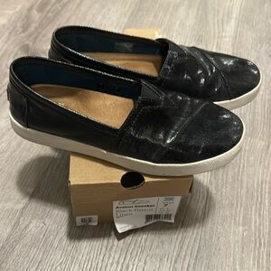Black Tom’s patent leather slip on loafers